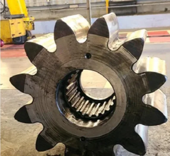 Machined gear resting on the workshop floor